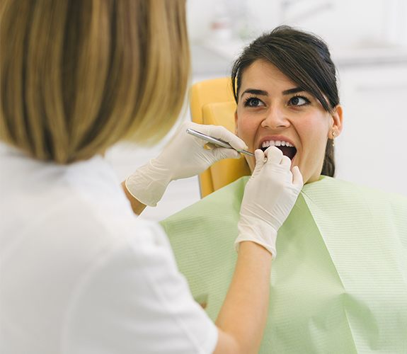 Woman receiving checkup to prevent dental emergencies