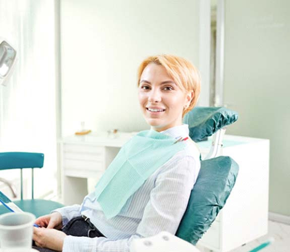 Woman sitting in treatment chair and smiling