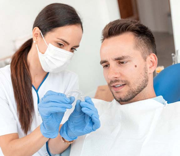 Dentist showing male patient a clear aligner