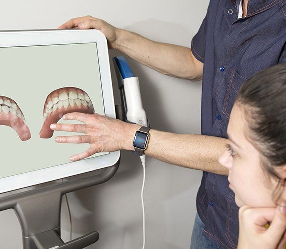 Dentist showing 3D bite model to patient preparing for clear aligners in Sycamore